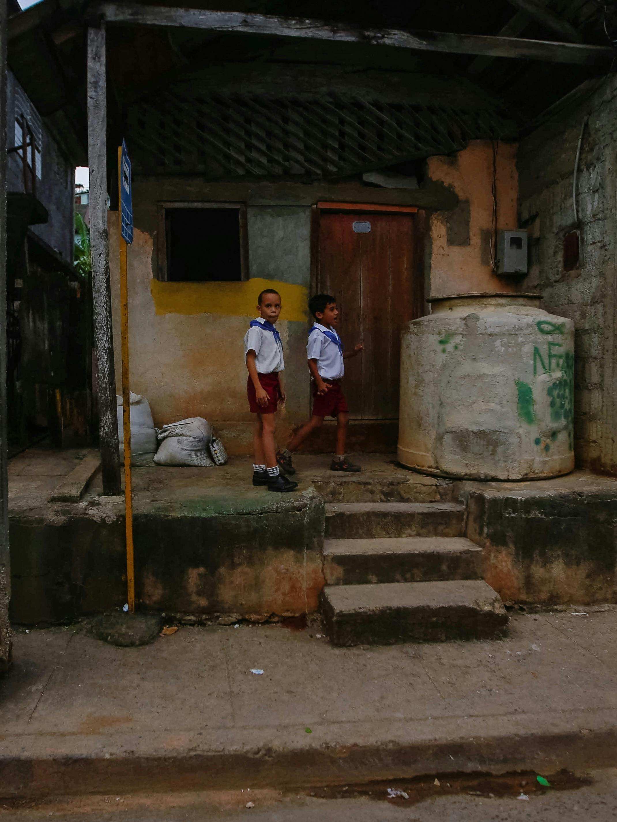 boys standing near house in village