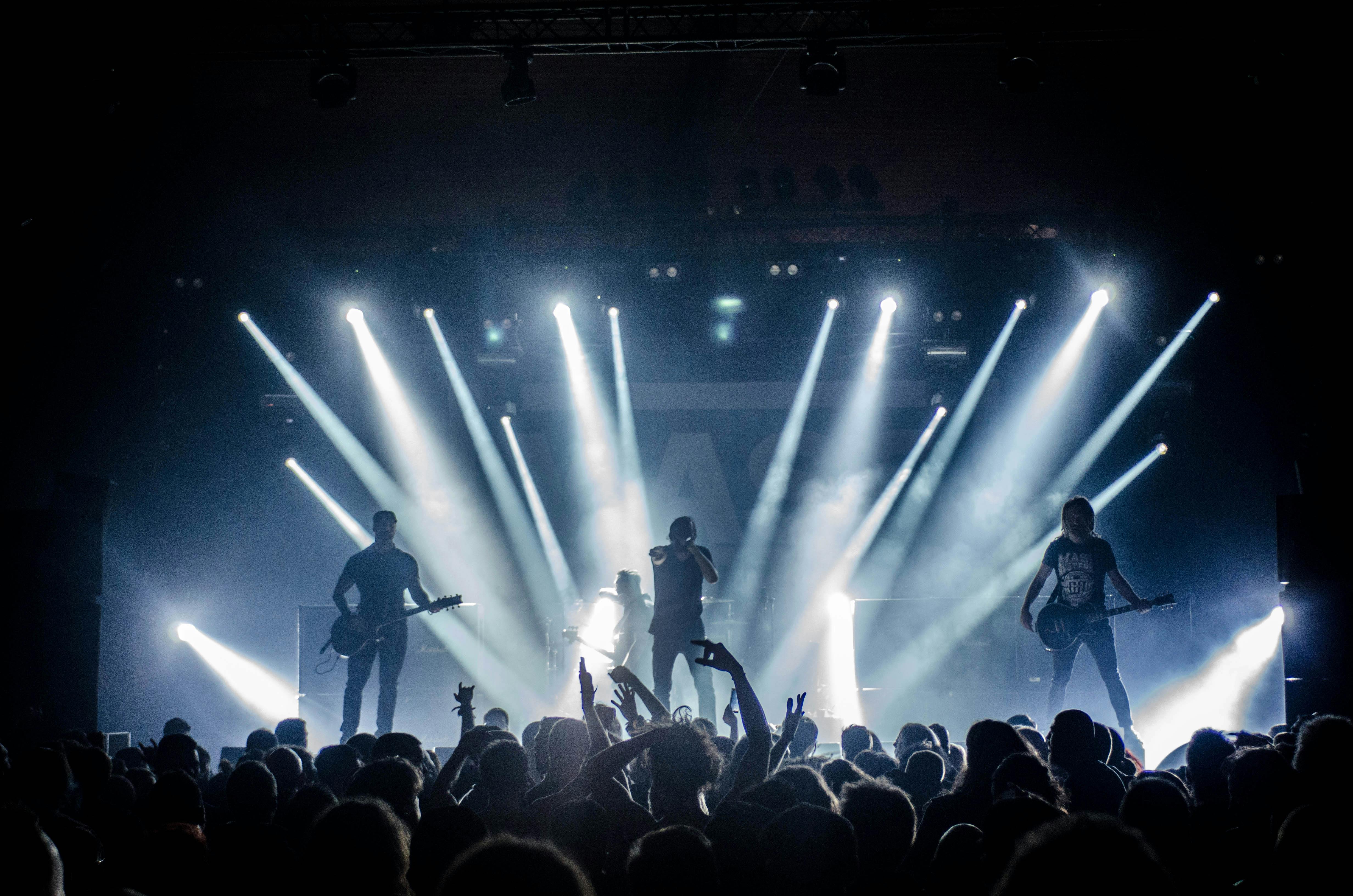 Singer Singing On Stage Beside Guitar Player And Bass Player Free Stock Photo