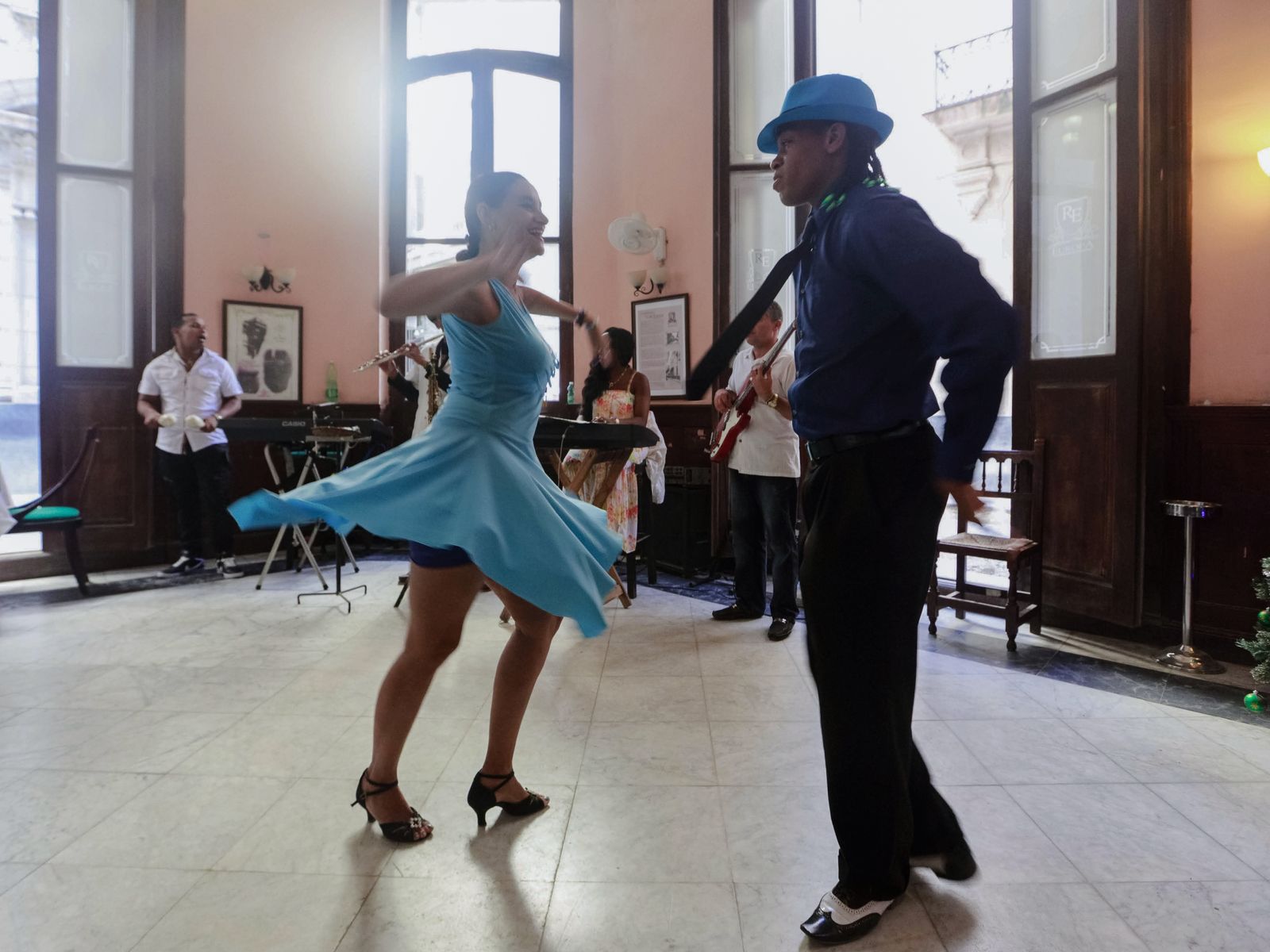 Merengue — lively couple dancing with a live band in a Cuban café. Stock photo.