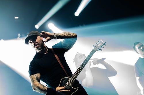 Gratis Hombre En Camisa Negra De Cuello Redondo Sosteniendo Una Guitarra Eléctrica Negra Foto de stock