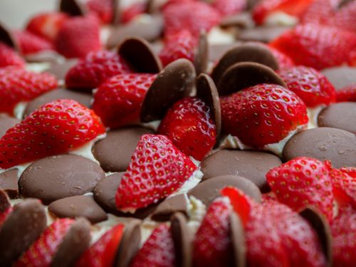 Free Close-up of fresh strawberries and chocolate discs on a dessert, emphasizing sweet flavors. Stock Photo