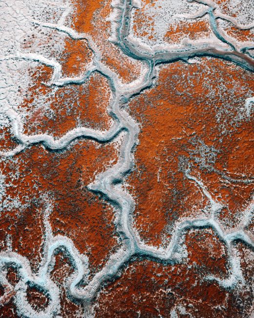 Aerial view of striking abstract patterns on the ground in rich earthy tones, showcasing nature's artistry.