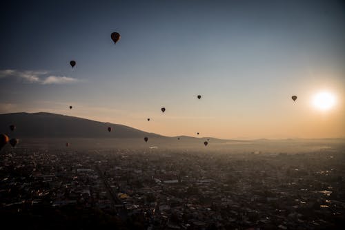 A group of hot air balloons over flying in mexico during sunrise