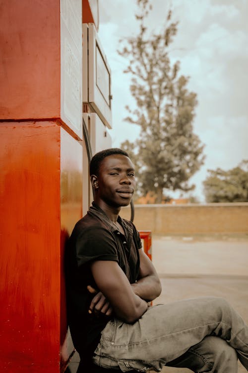 Man Sitting by Wall and Posing