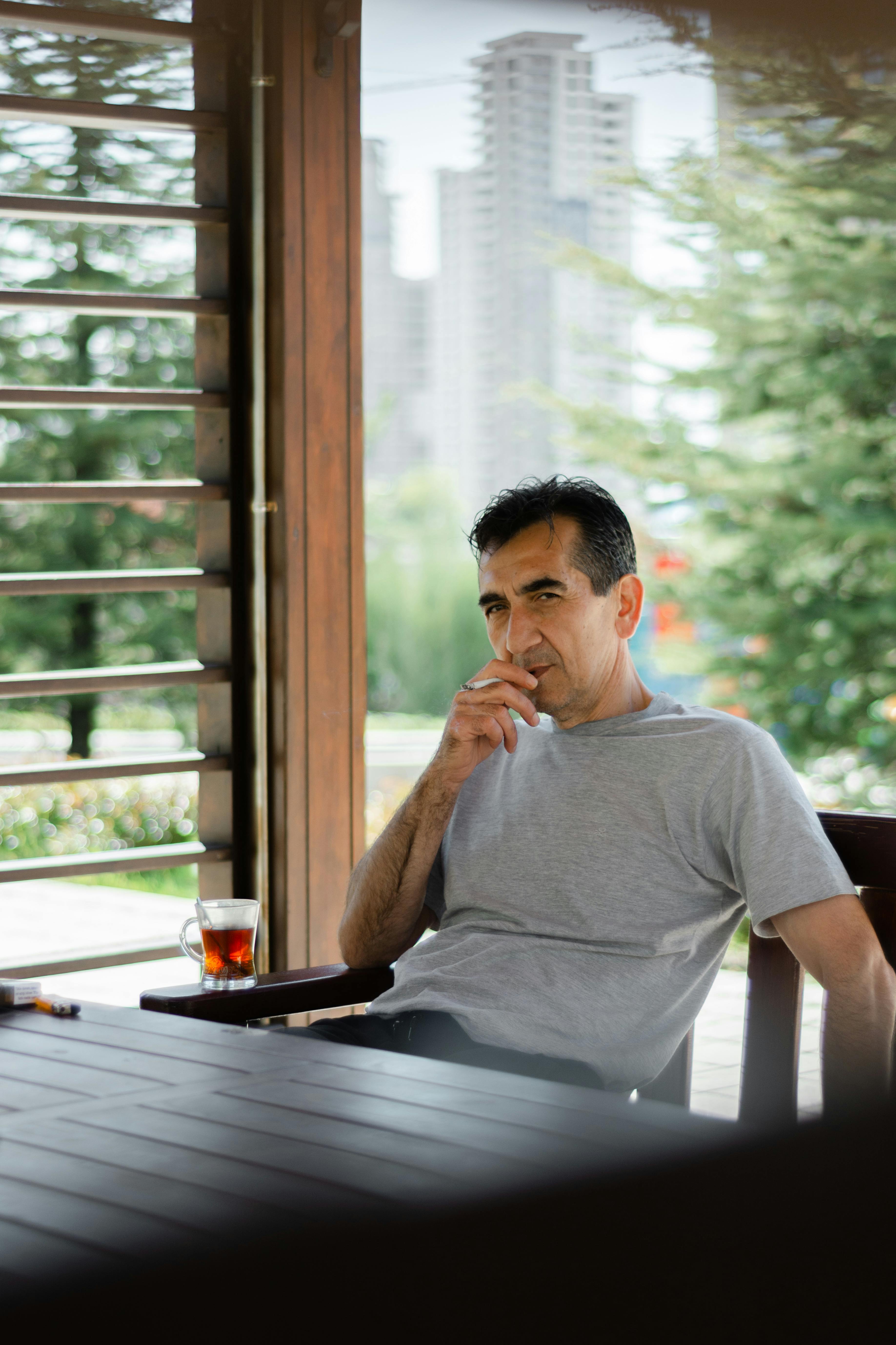 A man sitting at a table with a glass of wine