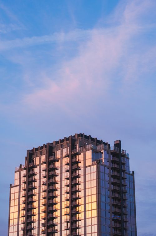 Free Sunlit glass facade of a modern building against a picturesque sunset sky in Orlando, Florida. Stock Photo