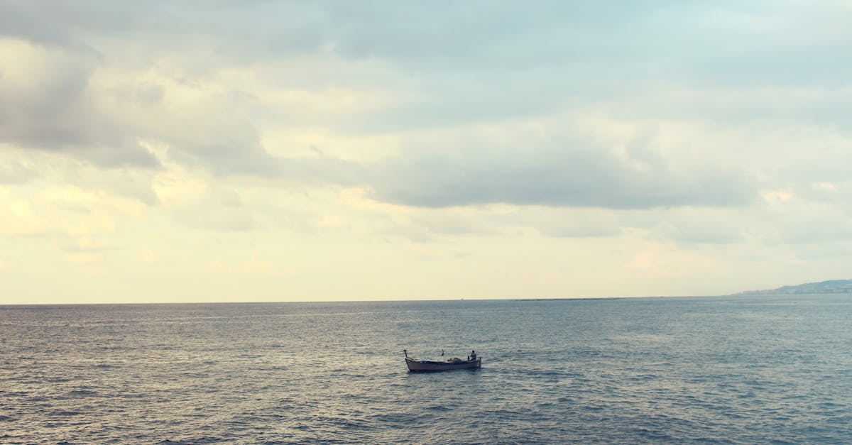 Wooden Boat on Water on Calm Body of Water during Cloudy Daytime Sky