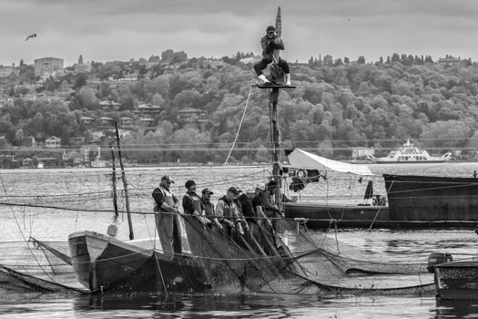 A group of fishermen with nets on a boat, capturing the essence of traditional fishing.
