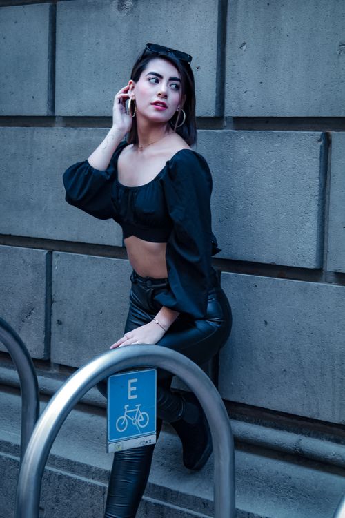 Free Chic woman in black fashion outfit poses against urban backdrop, showcasing modern style and confidence. Stock Photo