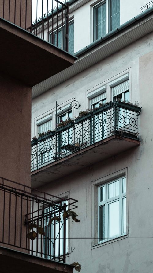 Free Vertical shot of a city building featuring balconies and windows, emphasizing urban living. Stock Photo