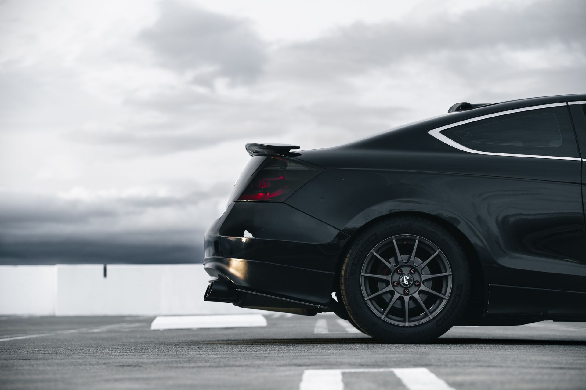 Side view of a sleek black car with modern design in a San Jose parking lot.