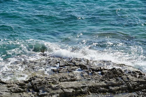 Free Dynamic waves crashing on Pula's rocky shore, capturing the vibrant essence of the Adriatic Sea. Stock Photo