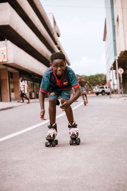 A young boy enjoys roller skating down an urban street, capturing the essence of fun and freedom.