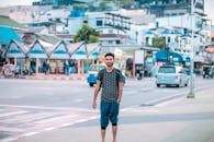 一名年轻人自信地站在繁华的城市街道上，展现着现代时尚