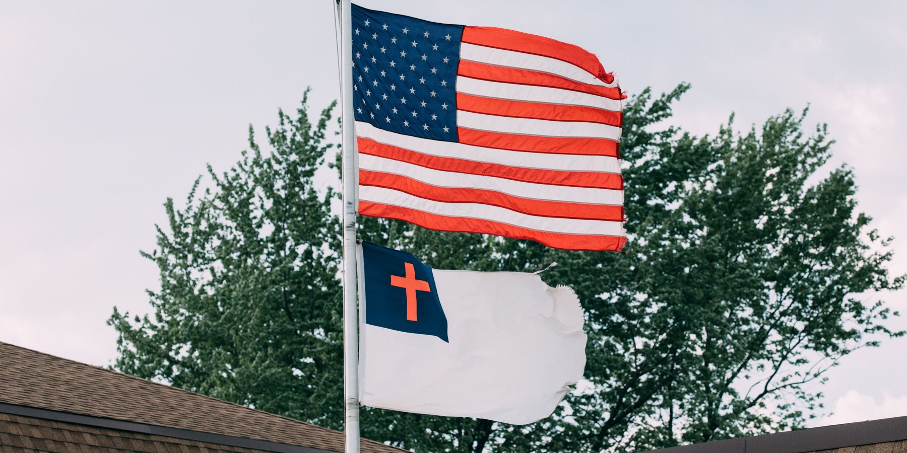 Patriotic display of American and Christian flags on rooftop in Springfield, IL.