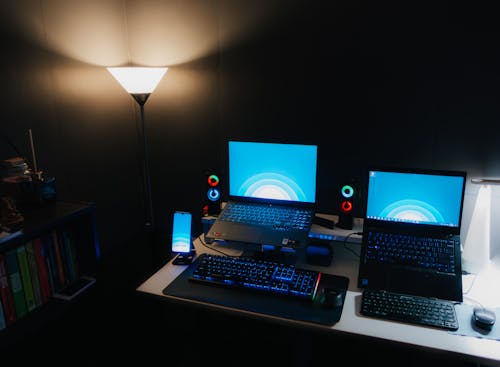 Photo of Blue Laptop Screens in a Dark Room