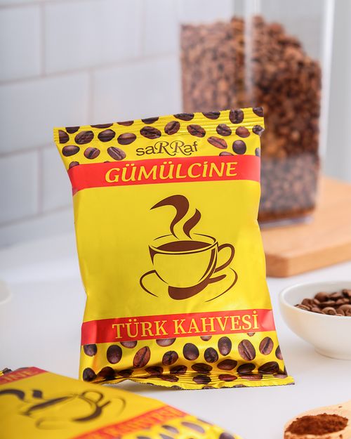 Free Yellow bag of traditional Turkish coffee on a counter with coffee beans in the background. Stock Photo