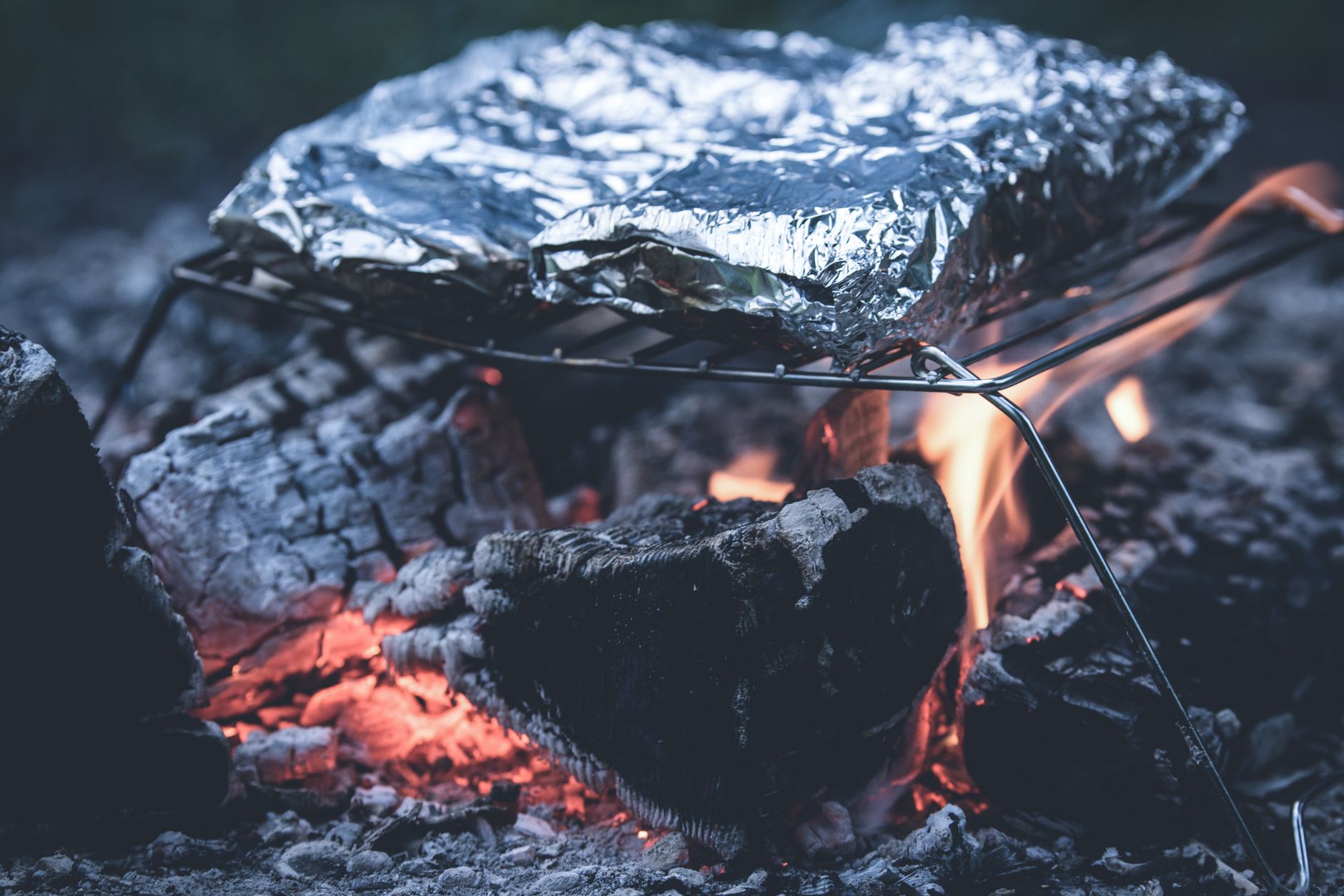 Fresh lemon being squeezed over vegetarian camping foil packets
