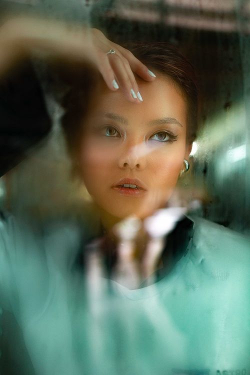 Free Artistic portrait of a woman looking thoughtful behind glass. Soft focus effect. Stock Photo