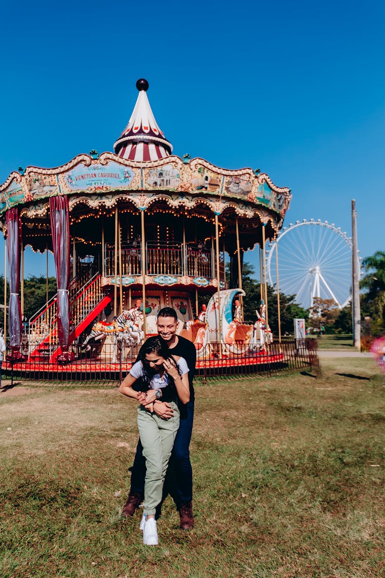 Couple Hugging Near Carousel