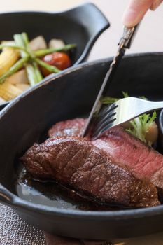 Close-up of a succulent steak with vegetables in a skillet, perfect for gourmet food presentations.