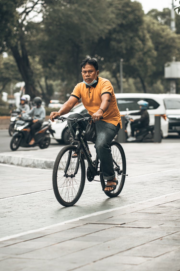 Man Cycling In Town