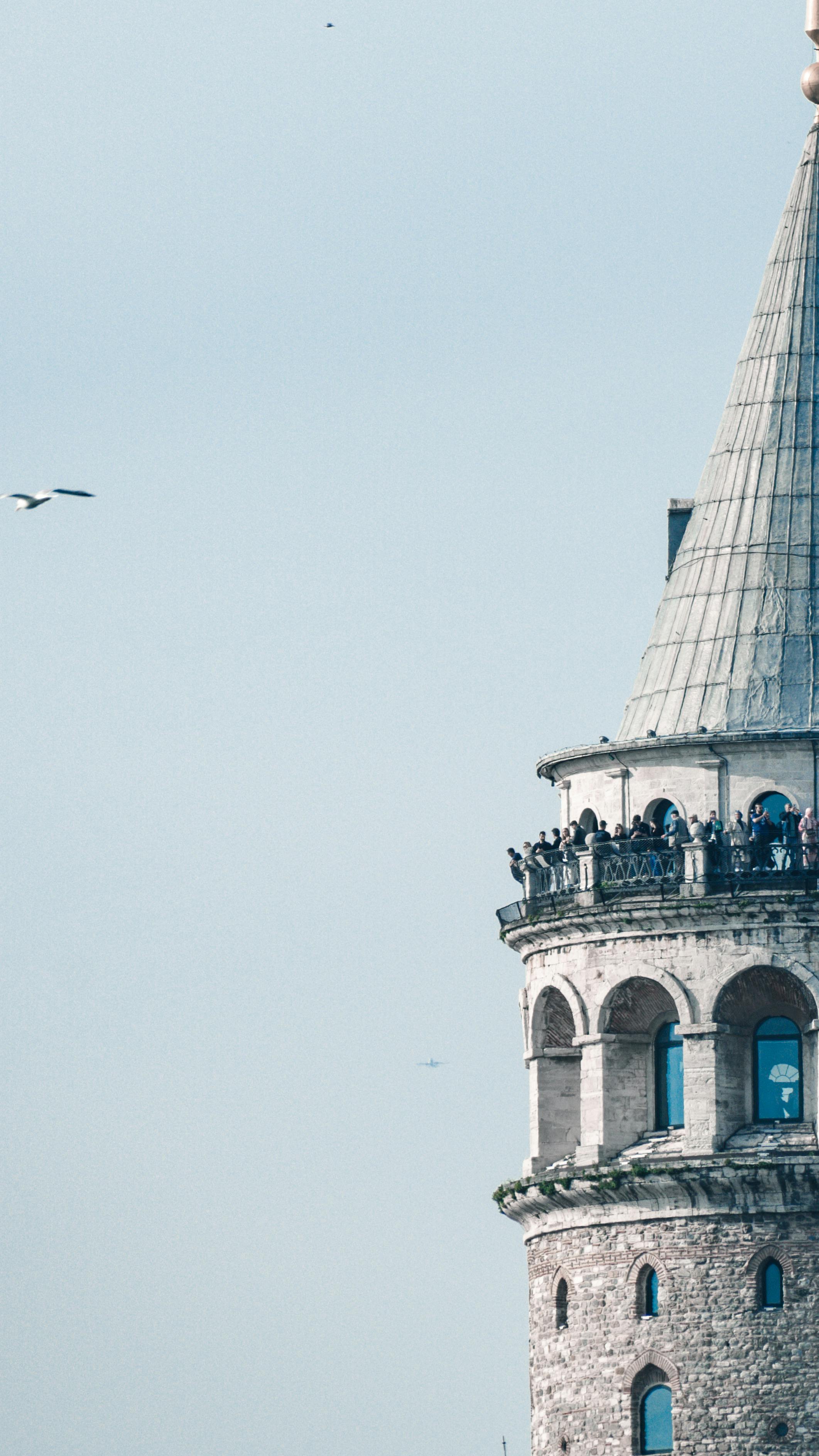 A close-up of the iconic Galata Tower against a clear sky in Istanbul, Turkey.
