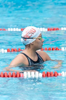 Female swimmer in pool wearing Peru swim cap. Focused and ready for the race.