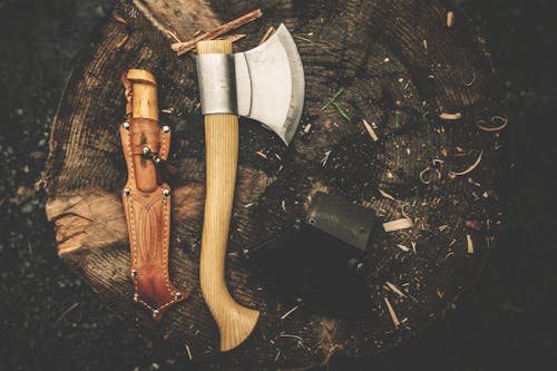 Free Brown Wooden Axe Besides Brown Leather Knife Holster Stock Photo