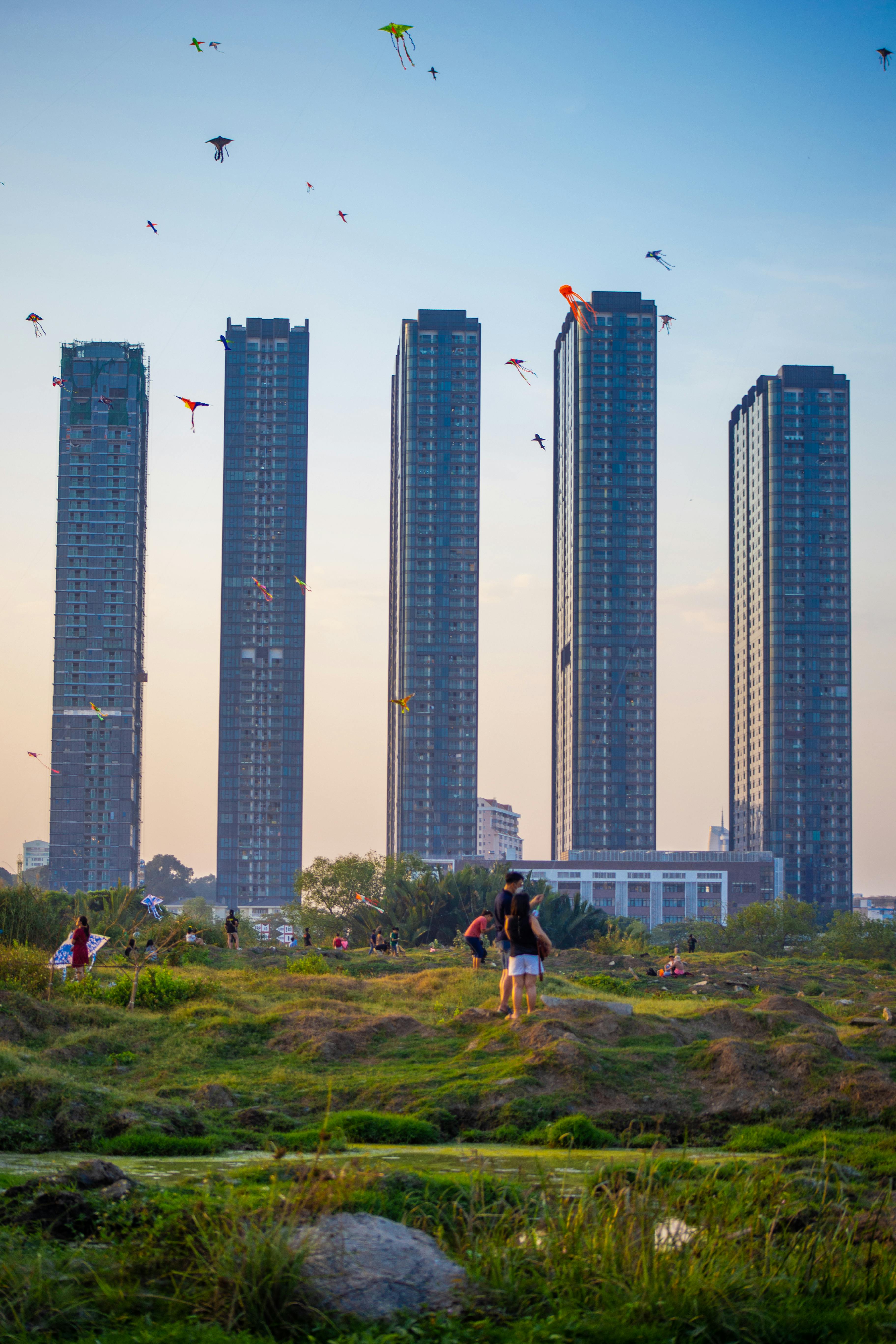A vibrant scene of people flying kites with a modern skyline backdrop in Ho Chi Minh City, Vietnam.