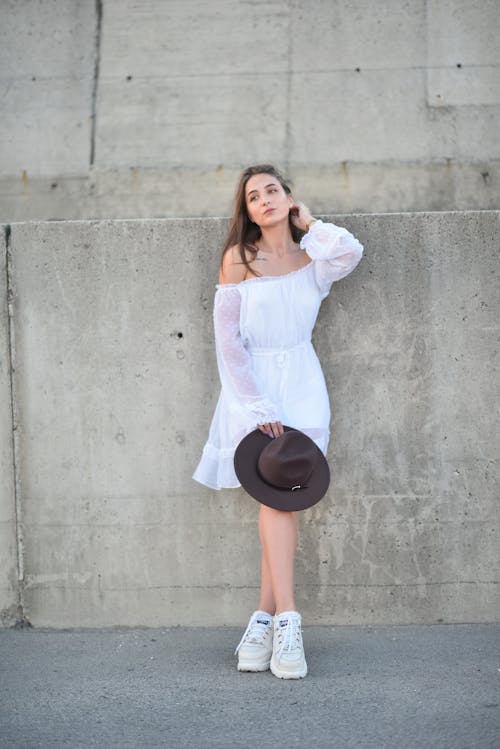 Woman in White Dress Posing with Hat