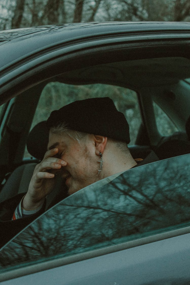 Young Man Sitting In A Car And Smiling 