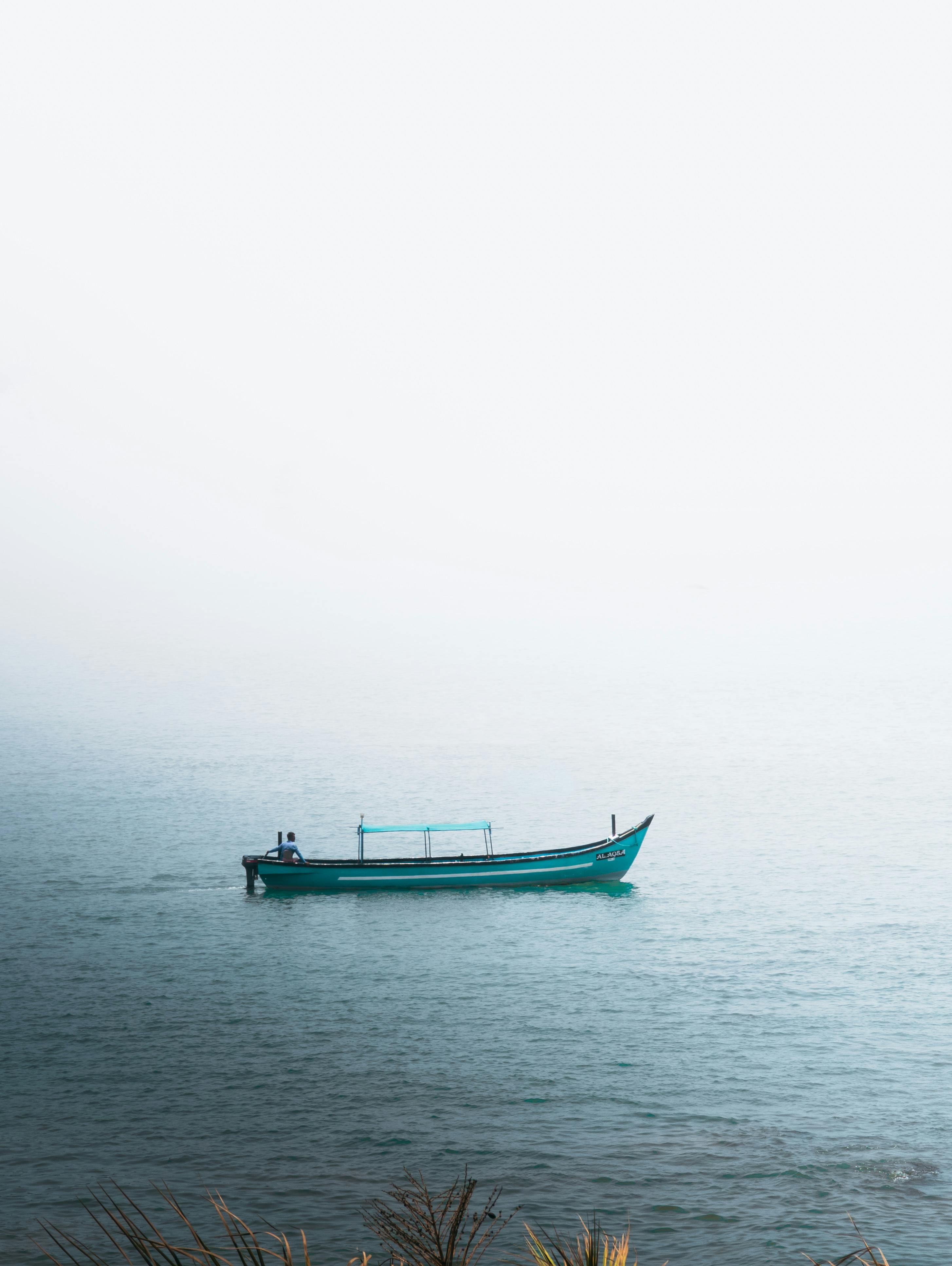 Serene boat drifting on misty Arabian Sea near Gokarna, India.