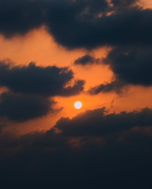Sun among Clouds on Sky at Sunset