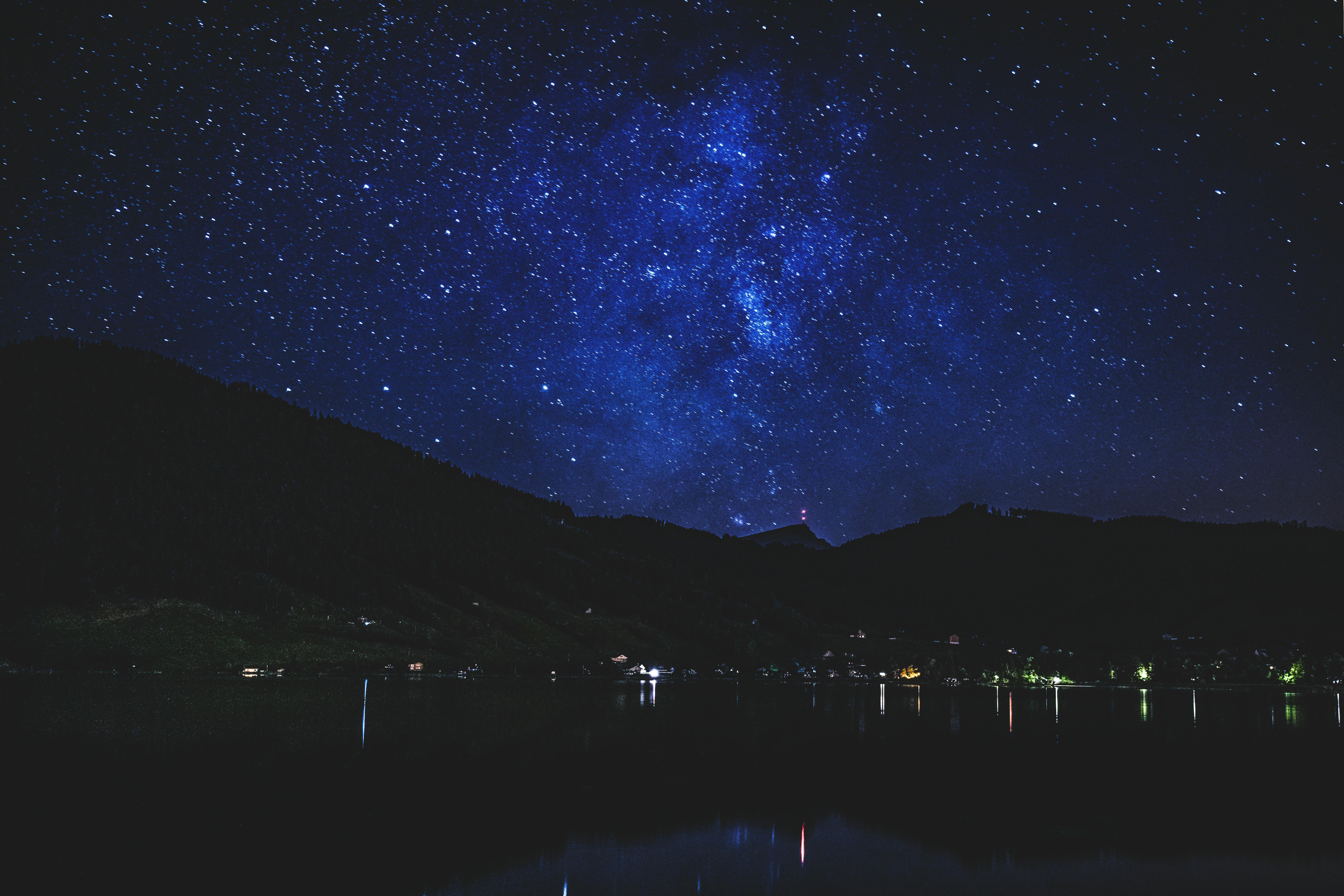 平静的湖面倒映着令人叹为观止的星空与山峦剪影