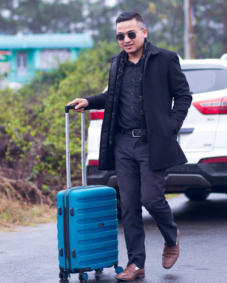 Man In Coat Walking With Suitcase