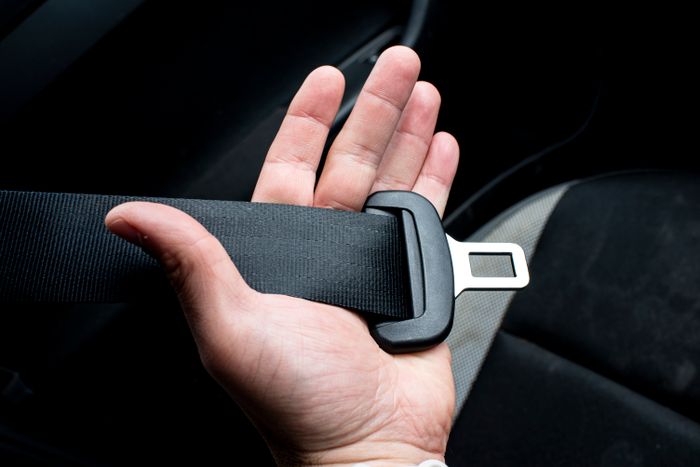 Hand holding a car seat belt