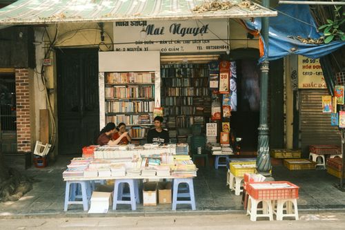 Free Outdoor Vietnamese bookstore with people sitting and books on tables. Stock Photo