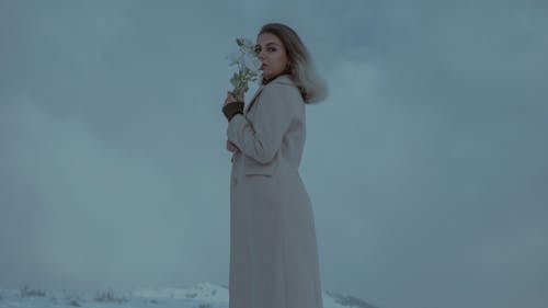 Blonde Woman in Coat and with Flowers