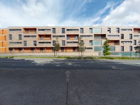 Contemporary urban residential building with geometric design and clear sky.