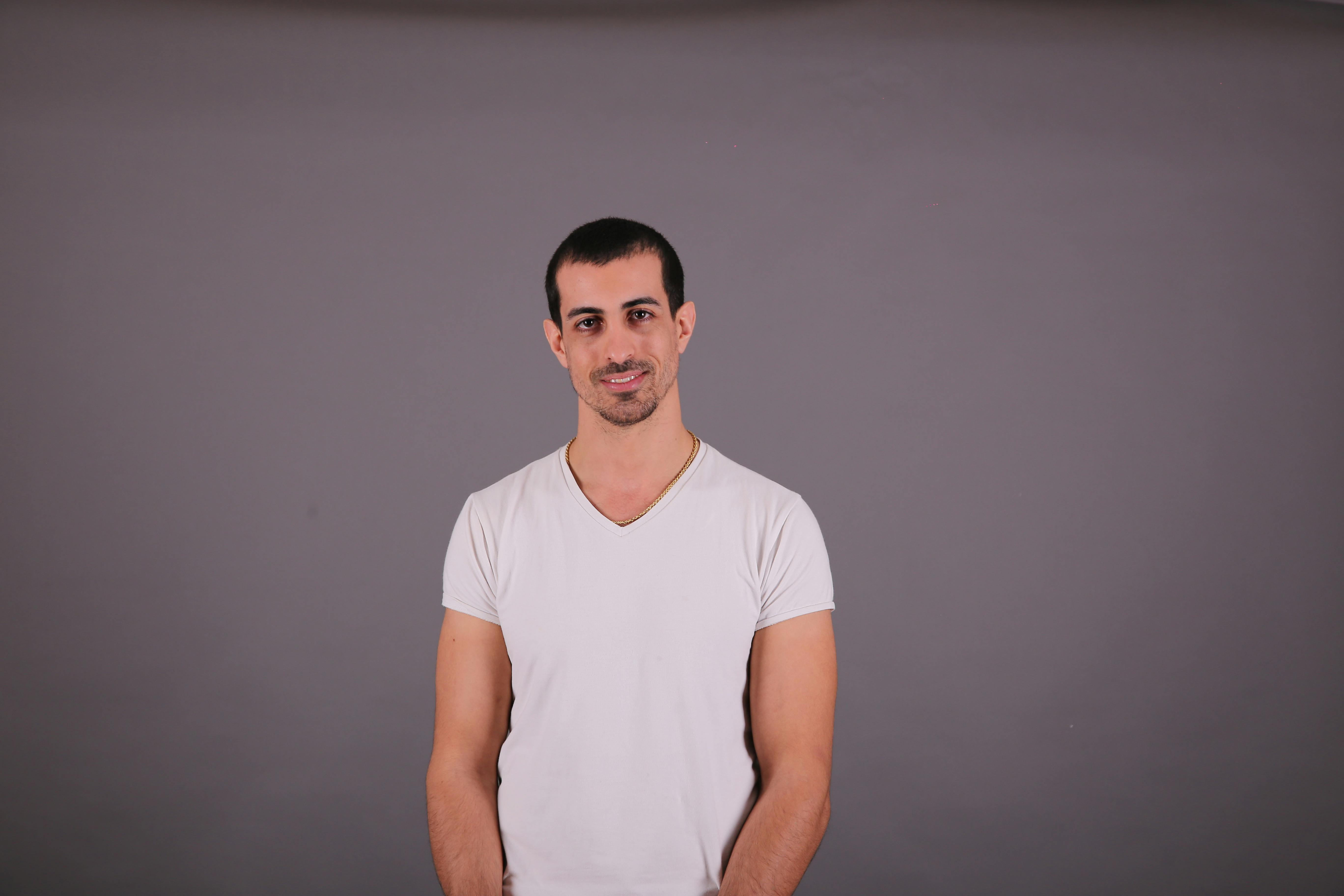 a man in a white shirt posing for a photo