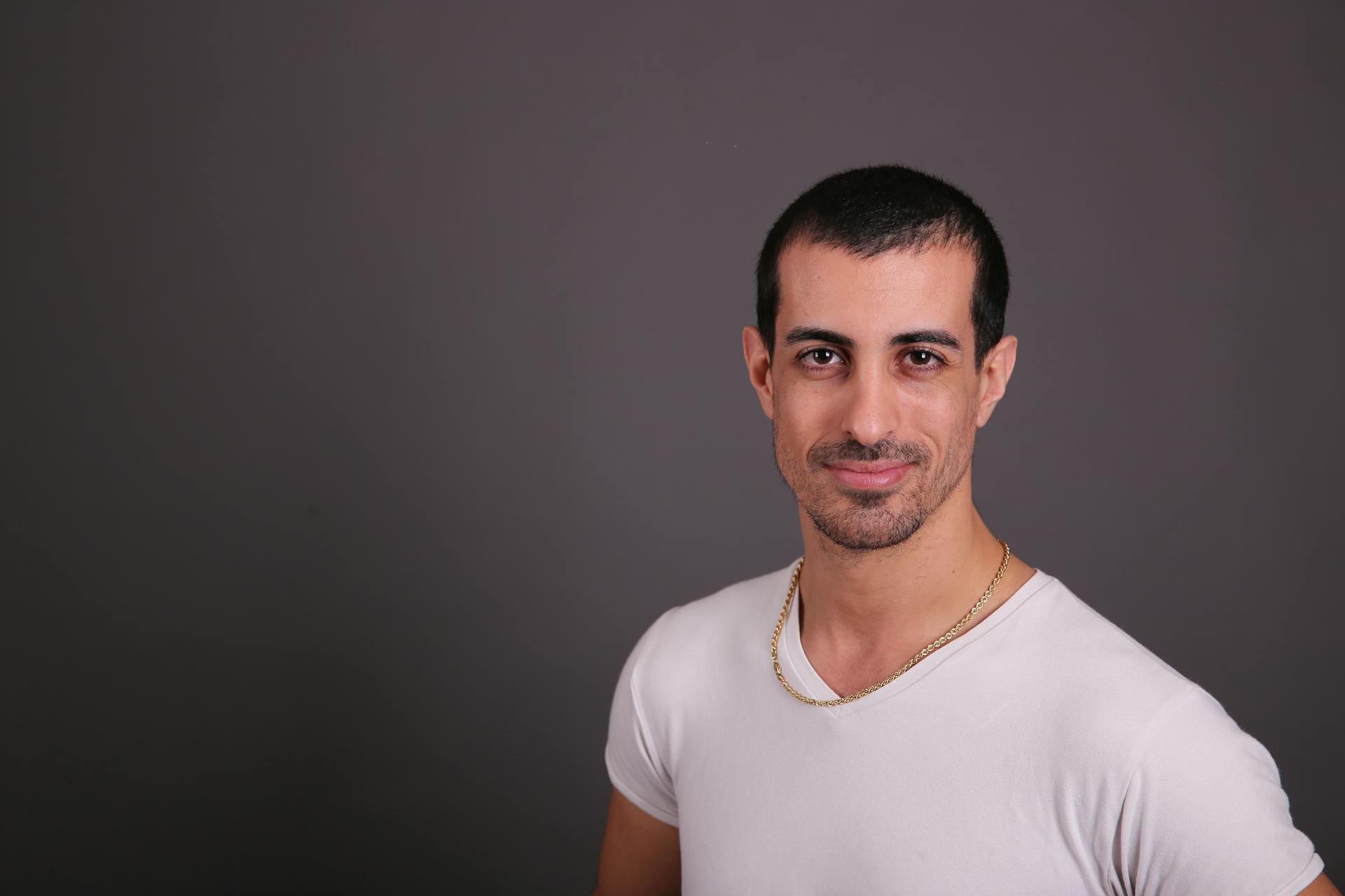 Studio portrait of a confident young man in a white t-shirt. Ideal for business and lifestyle themes.