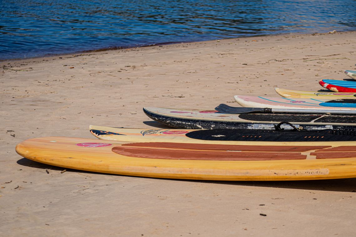 Kayaks arranged on a sandy beach for a SeaMotion water adventure