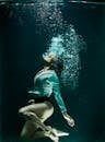 一张女子身着时尚服装潜入水下的戏剧性照片