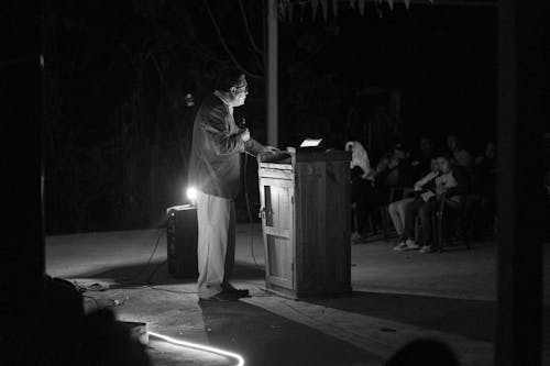 Man Speaking with Microphone at Night in Black and White