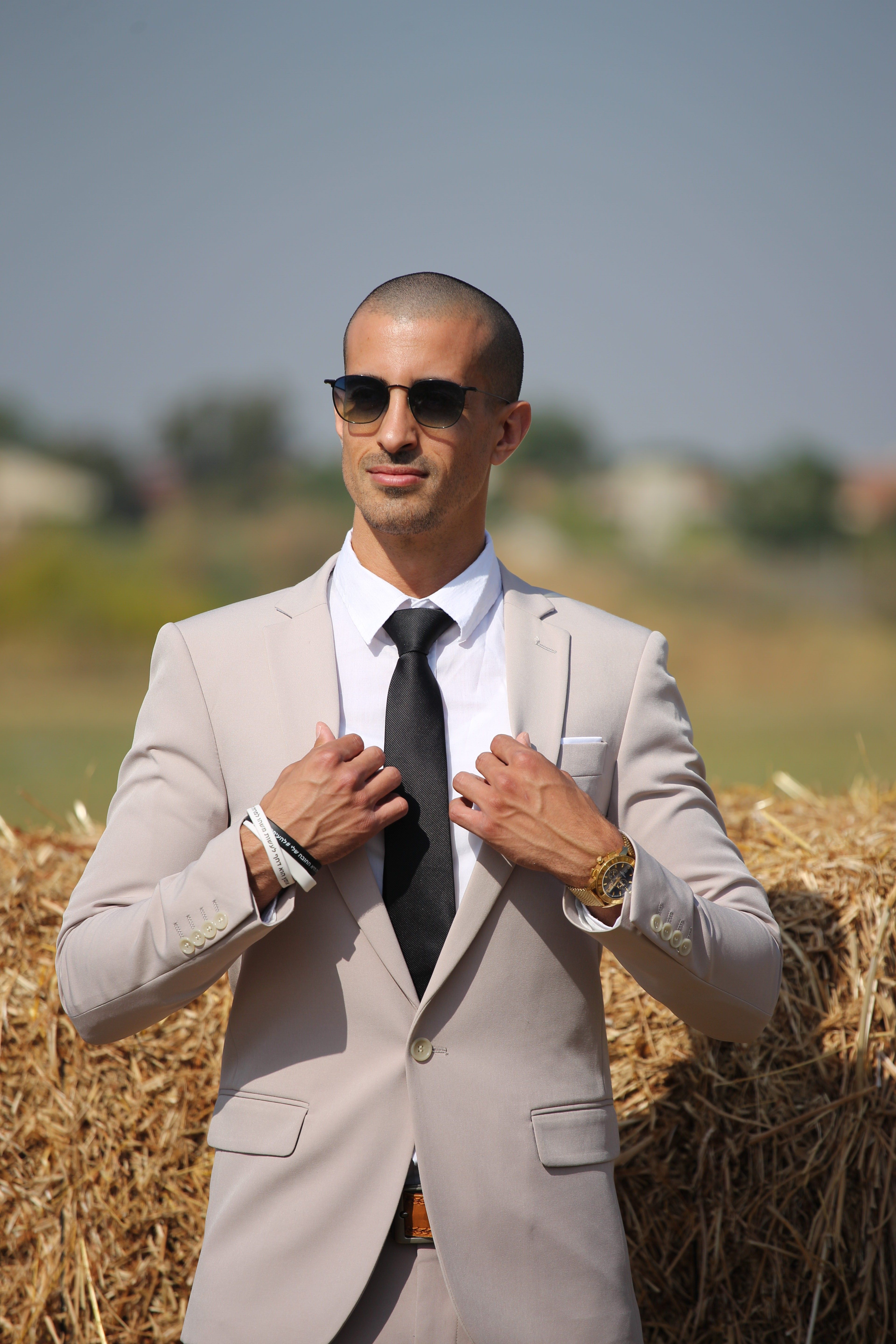 A man in a suit and tie adjusting his tie · Free Stock Photo