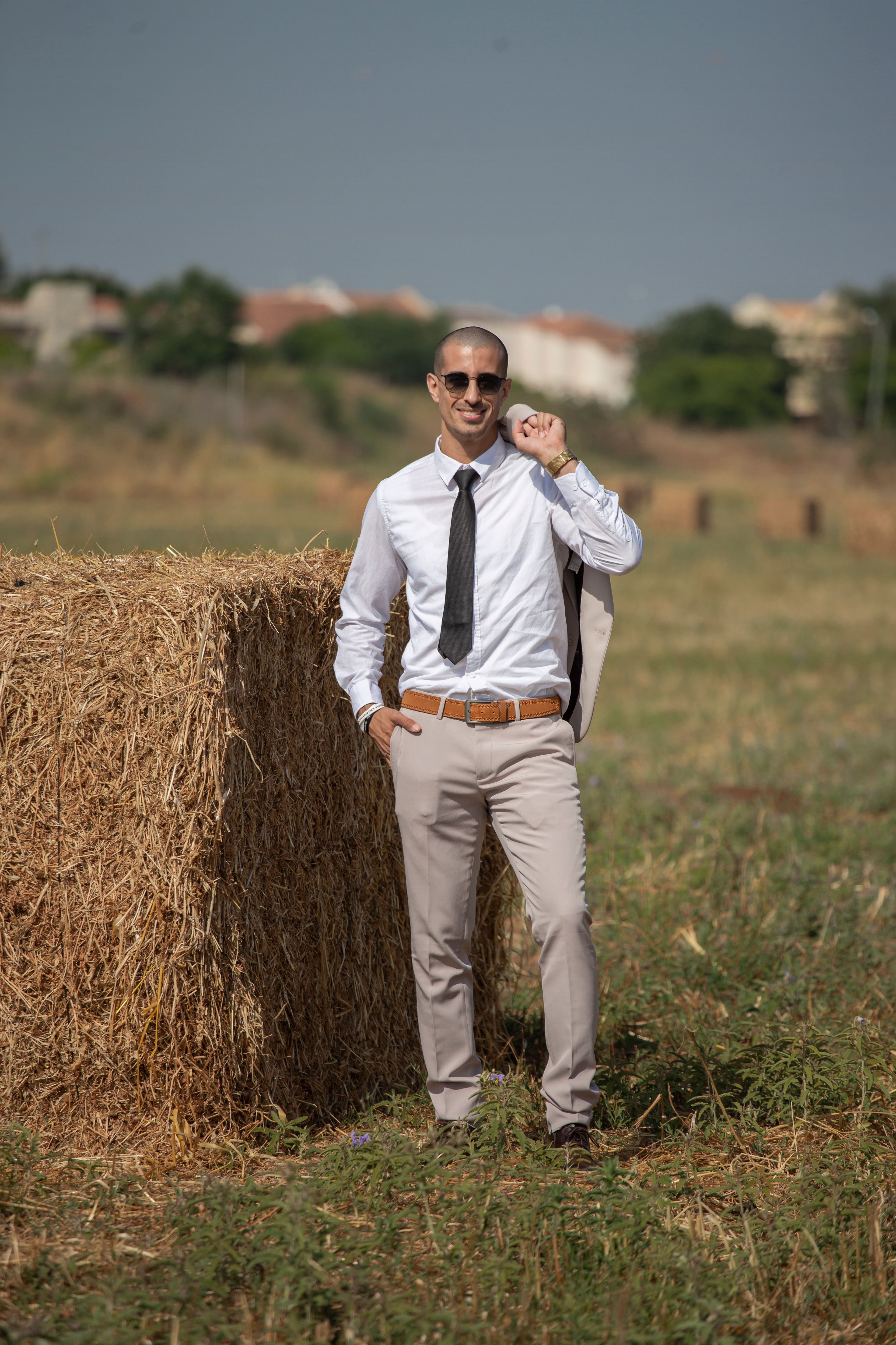 A man in a tie and sunglasses standing in a field · Free Stock Photo