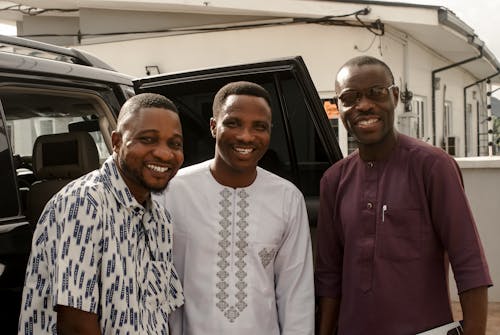 Smiling Friends Standing by Car