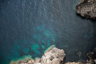 航拍镜头捕捉了岩石海岸线与深蓝色海水，凸显出自然美景