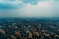 夜幕下雾气朦胧，广州的天际线在鸟瞰视角中显得格外壮观，高楼大厦巍然耸立